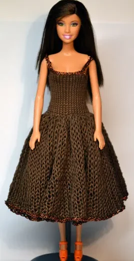 Barbie i brun stickad klänning med glitterkant och utsvängd kjol.