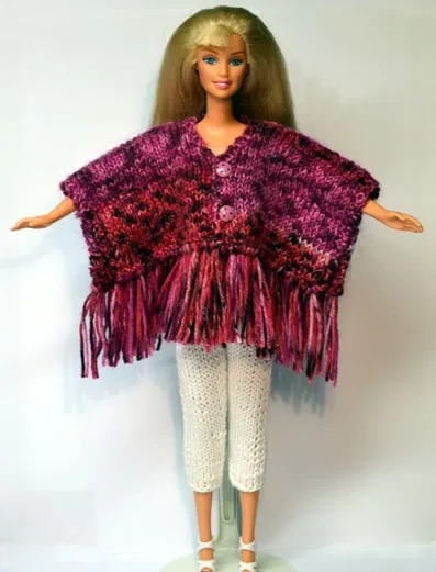 Barbie i lila melerad stickad poncho med fransar och vita byxor.