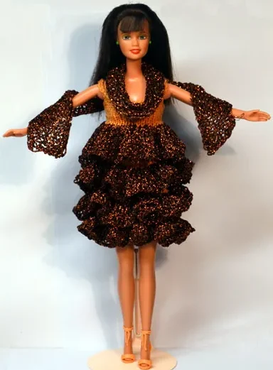 Barbie i brun glittrig klänning med volangkjol och vida ärmar.