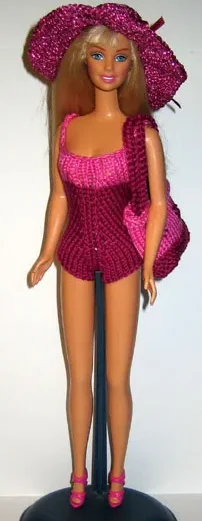 Barbie i cerise rosa stickad hatt och matchande glittrig outfit.