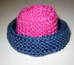 Stickad hatt för Barbie i cerise och blått med breda brätten.