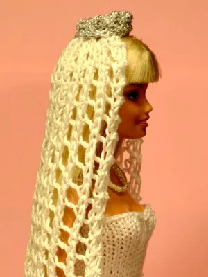 Barbie med vit hålmönstrad brudslöja och silvrig krona.